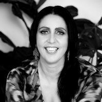 A young brunette woman smiles into the camera