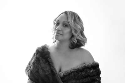 A striking woman wrapped in fur gazes at the camera