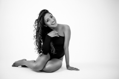 Beautiful asian woman sits casually on the floor, hair cascading over one shoulder