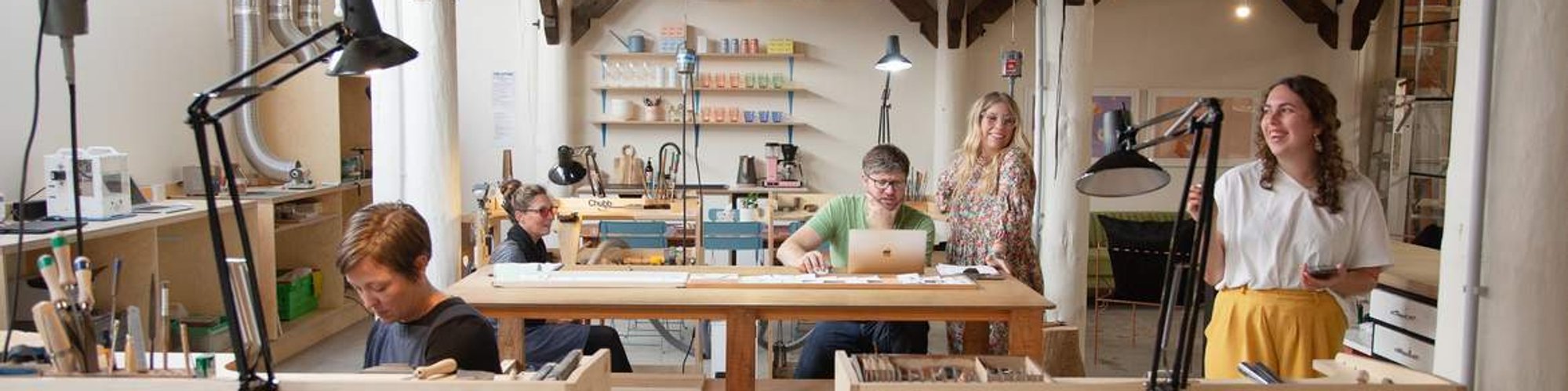 Five people work in a jewellery workshop all on different tasks