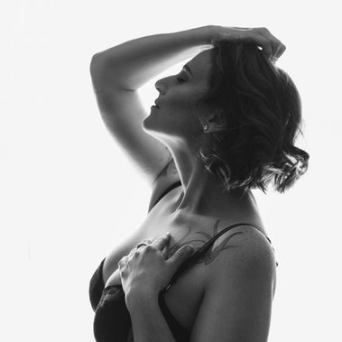 A slim brunette poses in a boudoir style