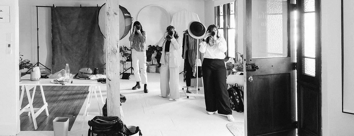 Three female photographers captured in a nelson photography studio