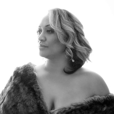 A woman is wrapped in fur, looking away from the camera