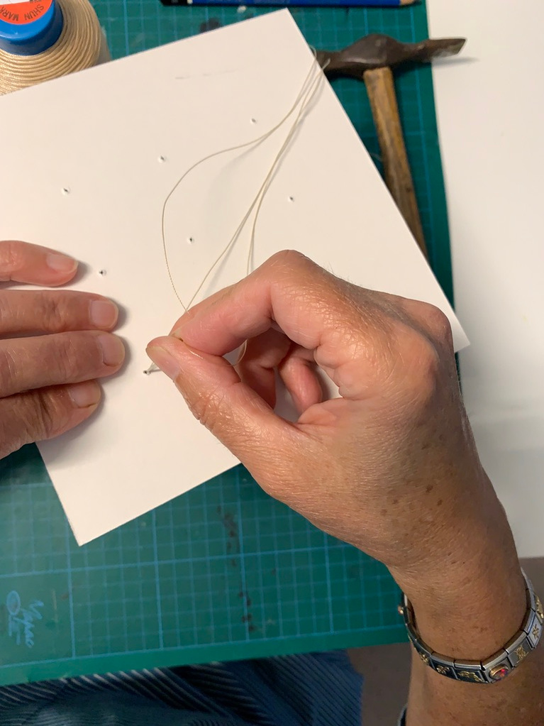 tie a knot when all holes have been threaded onto the wet artwork