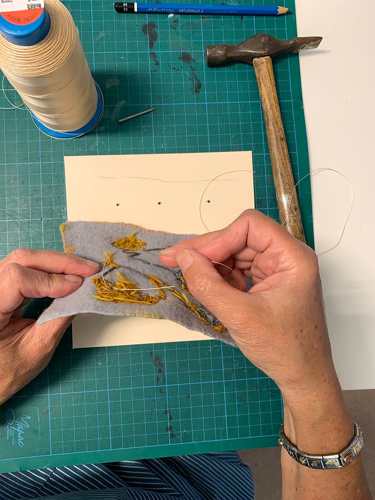 Secure the upholstery thread onto the back of the work 