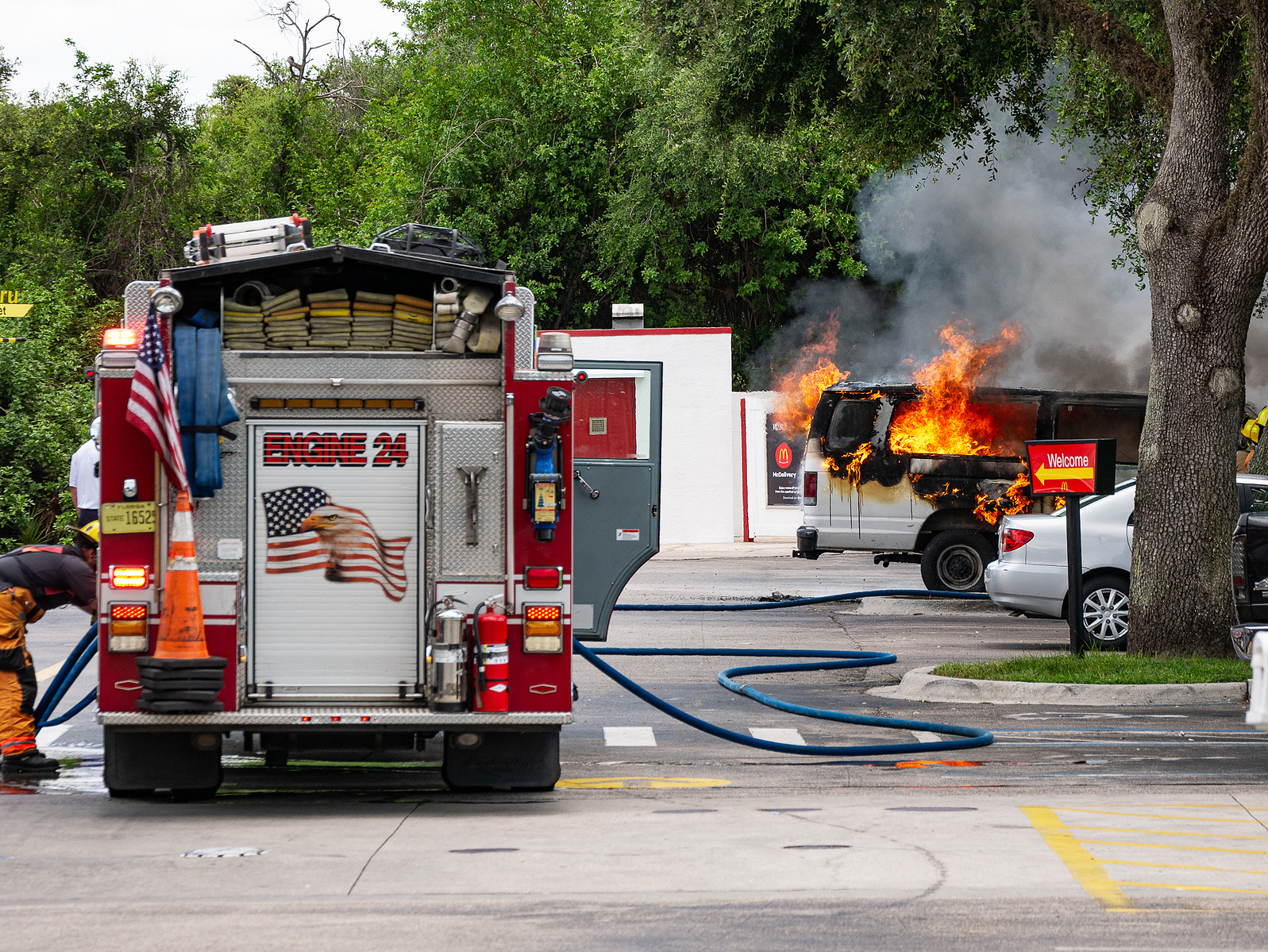 Firefighters respond to a vehicle engulfed in flames, a dramatic moment of action and urgency captured with Engine 24 on the scene.