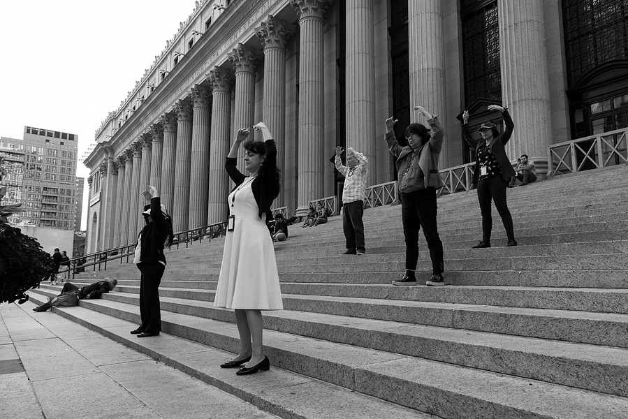 Members of a Falun Dafa practice group  disrupt the continuum by performing a meditation on the steps outside Penn Station, NYC, September 2024
