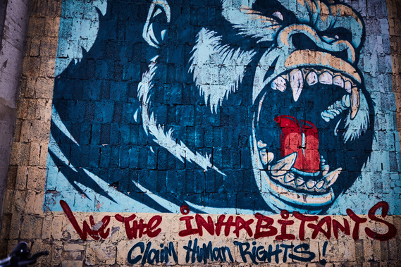 A painting on a wall of a blue gorilla shouting, with text written at the bottom saying 