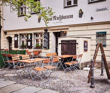 Outdoor seating with orange furniture in a pub courtyard in Berlin, Germany