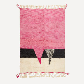A handmade Moroccan Berber rug with a bright pink, black and cream pattern and tassels at the top and bottom