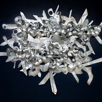 When My Scars-Abstract Art Piece With Various Shapes that Resembles Ties. The Ties are Bent in Various Ways. The Piece is Silver.