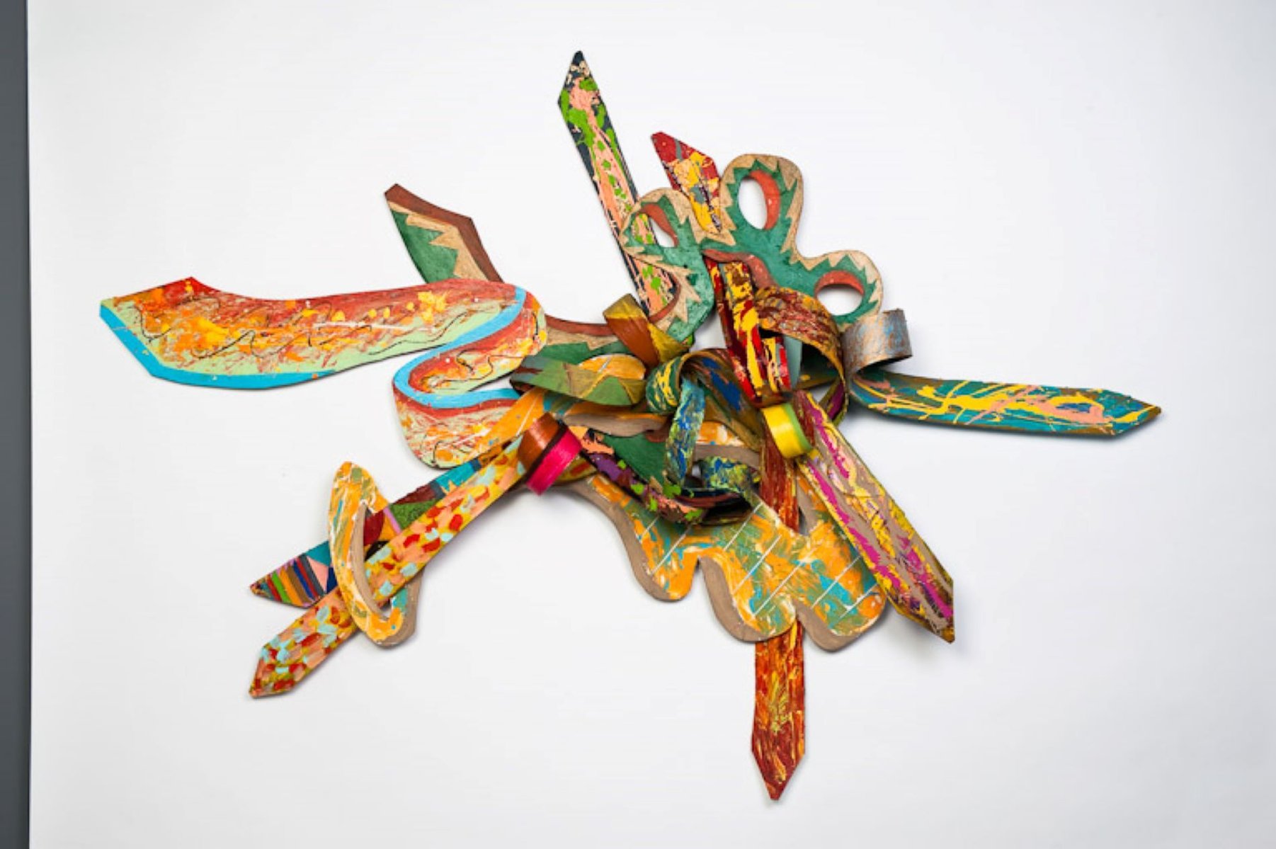 3 A. M. Wings For TC-Multicolored Abstract Art Piece Hung on A Wall With Various Shapes that Resembles Ties. The Ties are Bent in Various Ways. 