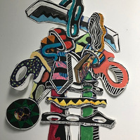 Livin Through the Process II Framed 33x41 2022-Abstract cutout art piece on paper that resembles a ladder with shapes and circles on the side and on top.  The colors of this piece are mainly red and green with multiple colors.