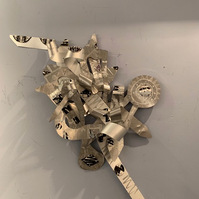 A Prayer Before-Abstract Art Piece With Various Shapes that Resembles Ties. The Ties are Bent in Various Ways. The Piece is Silver.