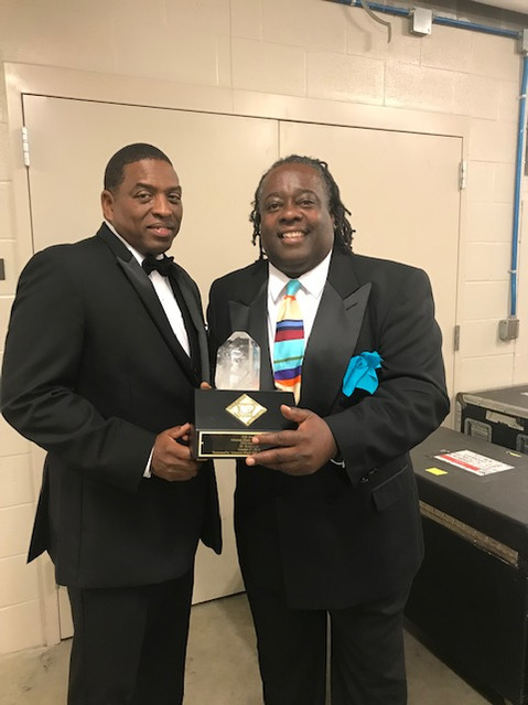 Arkansas Black Hall of Fame- Two Men in Tuxedos Posing For a Photo Holding a Award Trophy.