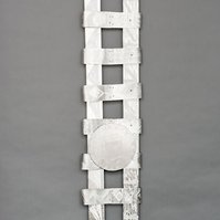 Swing Low Sweet Chariot For The Emmanuel 9  Back-Abstract Art Piece With Various Shapes that Resembles Ties. The Ties are Bent in Various Ways. The Piece is Silver With Small Color Detail.