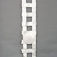 Swing Low Sweet Chariot For The Emmanuel 9  Back-Abstract Art Piece With Various Shapes that Resembles Ties. The Ties are Bent in Various Ways. The Piece is Silver With Small Color Detail.