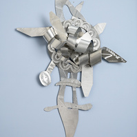Living On-Abstract Art Piece With Various Shapes that Resembles Ties. The Ties are Bent in Various Ways. The Piece is Silver. 