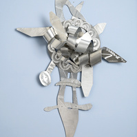 Living On-Abstract Art Piece With Various Shapes that Resembles Ties. The Ties are Bent in Various Ways. The Piece is Silver. 