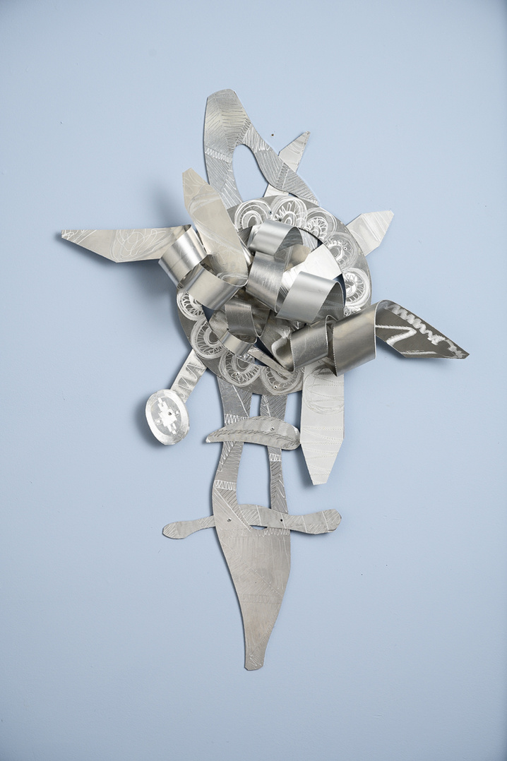 Living On-Abstract Art Piece With Various Shapes that Resembles Ties. The Ties are Bent in Various Ways. The Piece is Silver. 