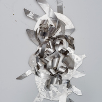 A Tale of Two-Abstract Art Piece Hung on A Wall With Various Shapes that Resembles Ties. The Ties are Bent in Various Ways. The Piece is Silver. 