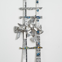 Seekin Higher Ground II Heaven-Abstract Art Piece With Various Shapes that Resembles Ties. The Ties are Bent in Various Ways. The Piece is Silver With Small Color Detail.