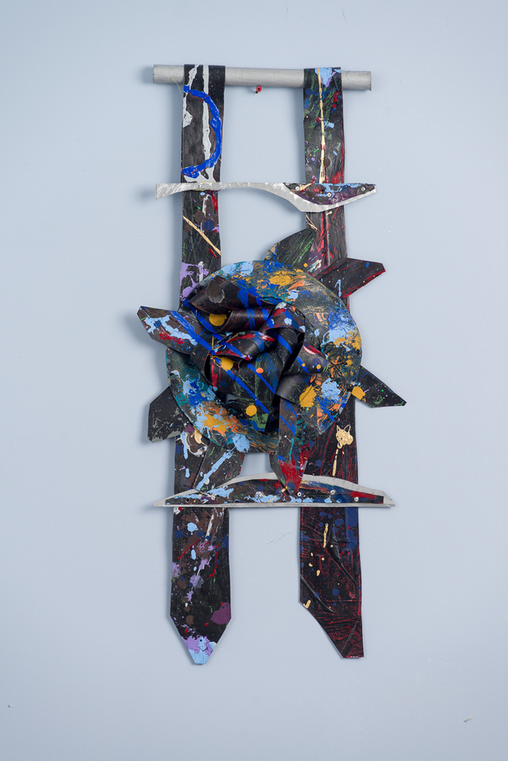 Midnite Prayers-Abstract cutout art piece on paper that resembles ladder  which has a circle in the middle. The colors of the piece are mostly black with multicolor splatters.