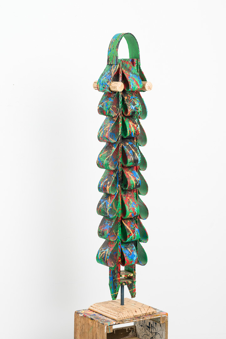 Triumph Over Fears- Totem Made of Ties with a Bright Green Base Color and Multicolor Splatter on a Wooden Base.