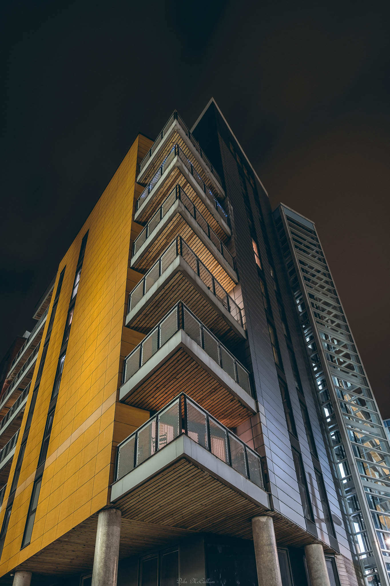 Looking up at apartment blocks with a wide angle lens at night with the lighting from the buildings illuminating the images