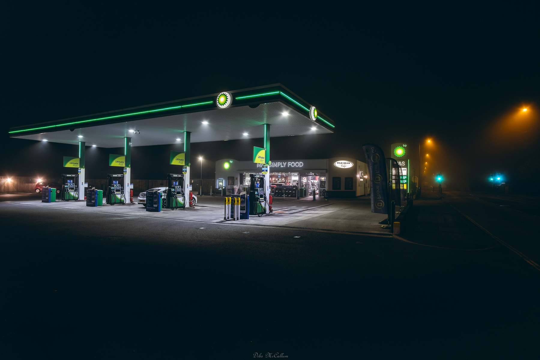 BP petrol station in the fog at night looking dark but with the neon lighting from the forecourt illuminating everything