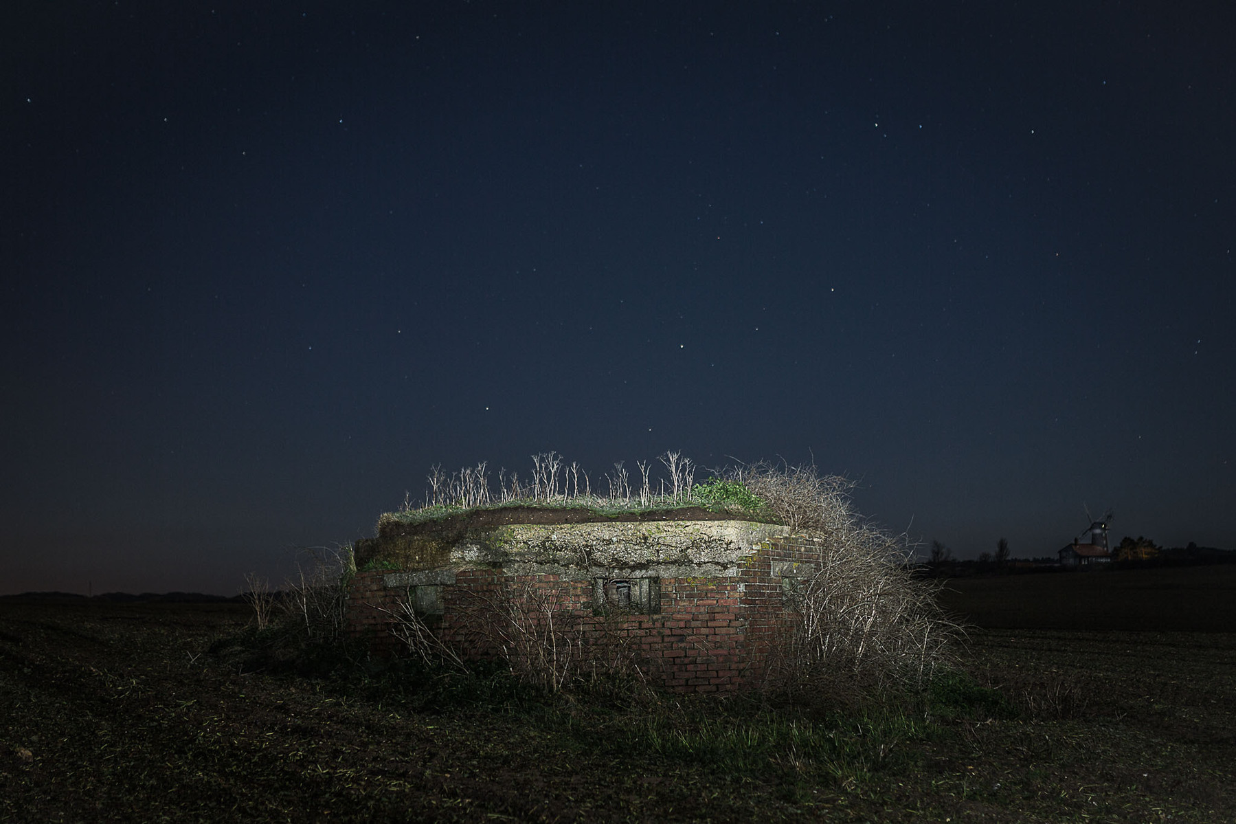 WW2 BUNKER pillbox on the cliff edge at night illuminated with flash lighting.