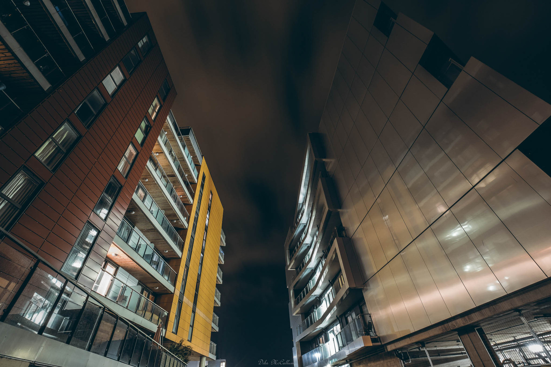 Looking up at apartment blocks with a wide angle lens at night with the lighting from the buildings illuminating the images