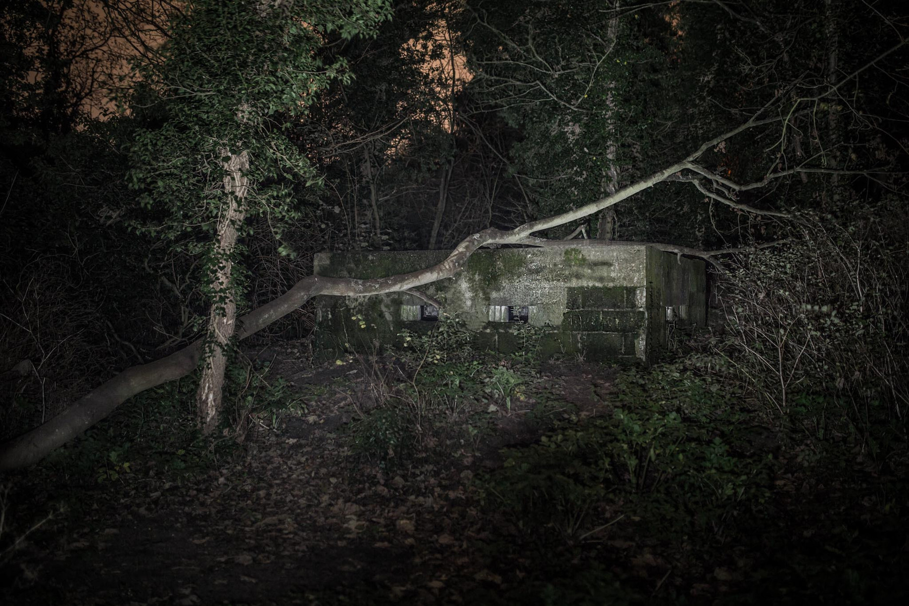 WW2 BUNKER pillbox on the cliff edge at night illuminated with flash lighting.