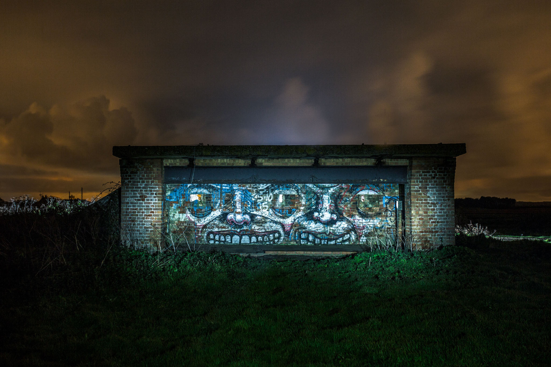 WW2 gun battery on the cliff edge at night illuminated with flash lighting.