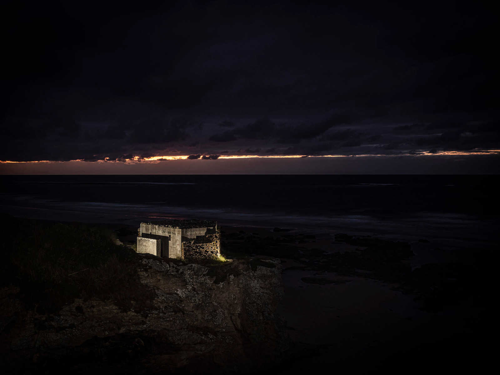 WW2 BUNKER pillbox on the cliff edge at Covesea in Moray at night illuminated with flash lighting.
