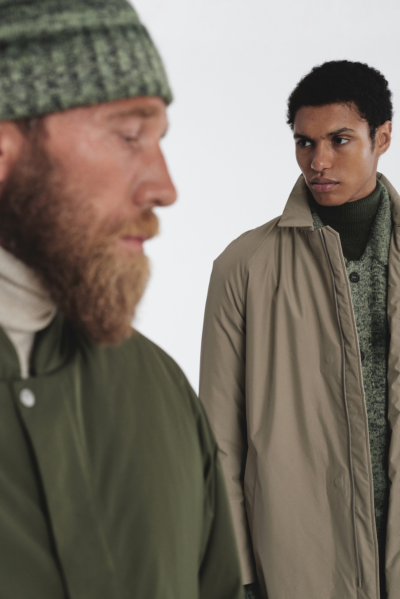 Explore contemporary style with our fashion-forward image featuring two men adorned in eco-friendly attire. Witness sophistication as one model effortlessly flaunts a striking green wool Oeko-Tex certified jacket, while the other exudes timeless elegance.