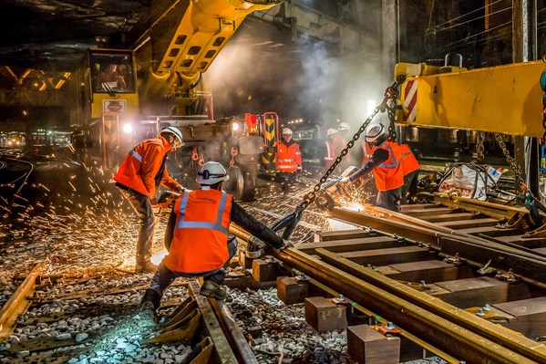 Chantier ferroviaire, voie ferree, grue Kirow permettant de changer des voies ferres sous catenaires, ouvriers, casque de securite, gilets fluorescents, depose de l'appareil de voie...Chantier de SNCF Reseau (ex RFF) la gare de l'Est, remplacement d'appar