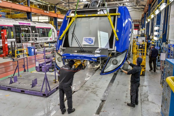 Site de production Bombardier, chaine de fabrication des rame Regio2N, employe de Bombardier, ouvrier, mise en place de la carrosserie sur le nez de l'automotrice, rame de train TER Francilien ..Regio 2N, TER a deux niveaux, automotrice articulee..SNCF,
