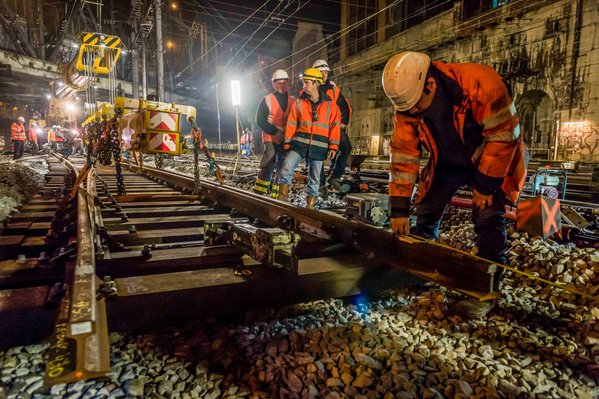Chantier ferroviaire, voie ferree, grue Kirow permettant de changer des voies ferres sous catenaires, ouvriers, casque de securite, gilets fluorescents, depose de l'appareil de voie...Chantier de SNCF Reseau (ex RFF) la gare de l'Est, remplacement d'appar