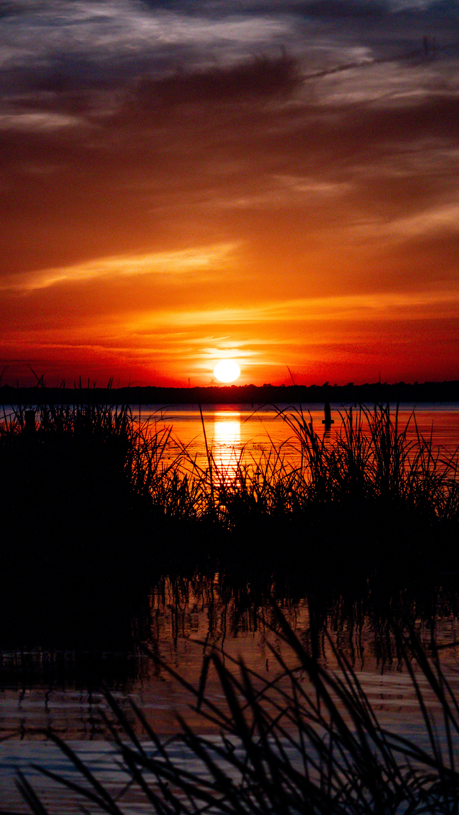 A beautiful sunset from across the reservoir with vibrant colors of orange, yellow and red.
