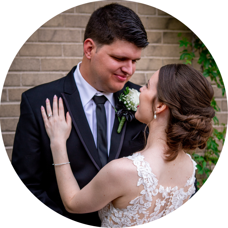 Bride and Groom share a loving glance in front of an ivy covered brick wall in downtown Plymouth, Michigan before their wedding reception at The Meeting House begins.