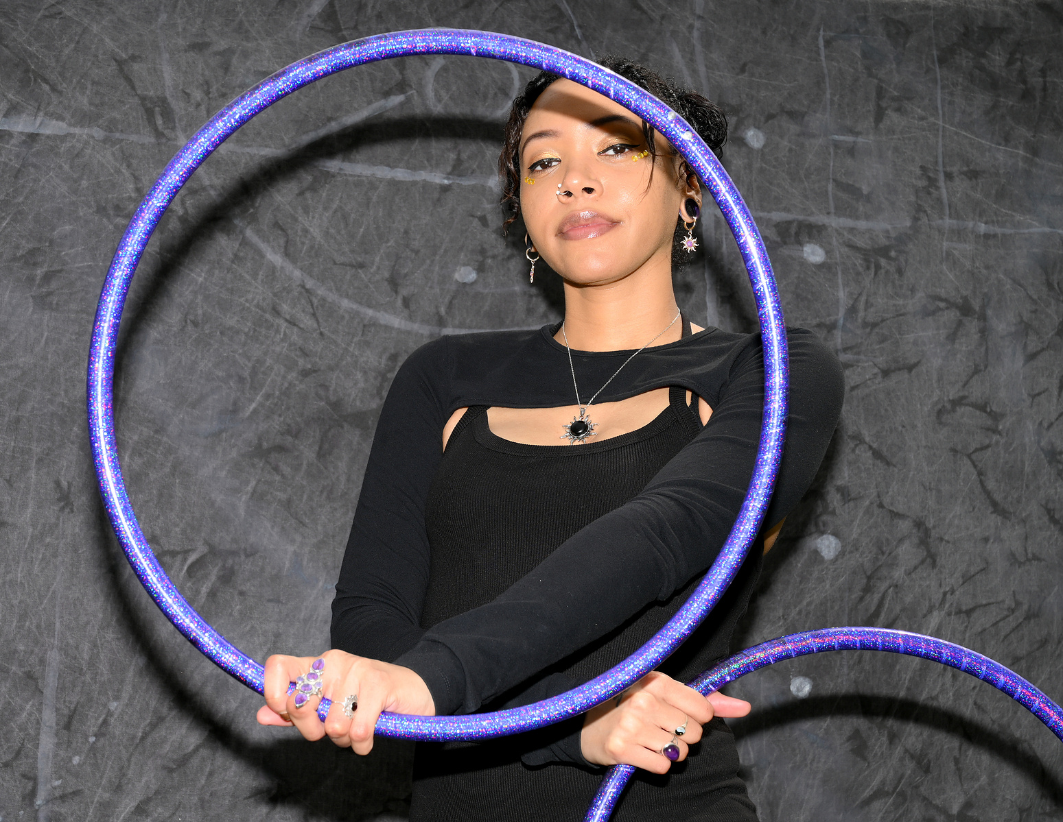 Mahogany Adio poses for a portrait with her hula hoops on Monday, April 15, 2024, at Peace Park in Columbia. Adio is the group leader of Ultraviolet, a fire dancing troupe.