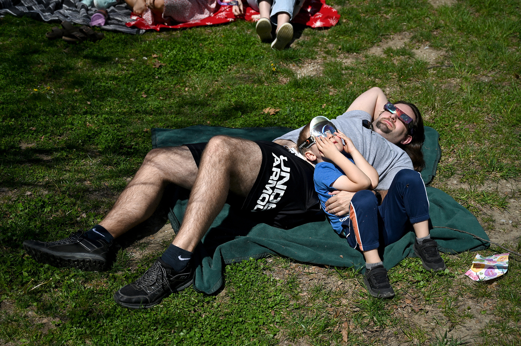 Evan Oelrichs, 5, watches the solar eclipse with his father Clark on Monday, April 8, 2024 at the Children’s School at Stephens College in Columbia. Dozens of families, like the Oelrichs, gathered to watch the eclipse at the Children’s School, where the e