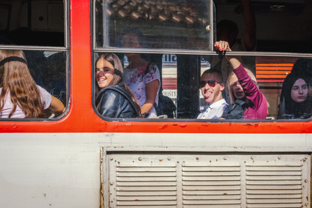 Young people on a bus making faces at passers-buy in Sarajevo, Bosnia