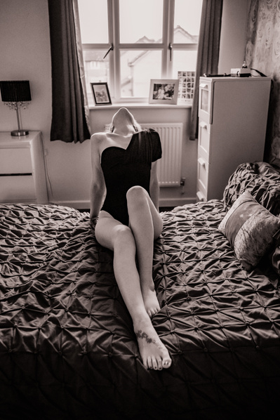 Boudoir model leans back on bed, nicola cooper photography, empowerment boudoir photoshoot, Cheshire, uk