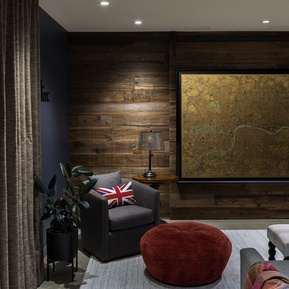 Reclaimed wood barn wall hiding a television. English themed room.