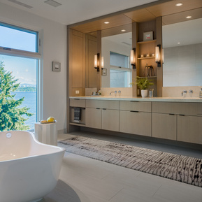 Primary bathroom with hidden side cabinets, recessed drawers, lighting with sconces, bathtub by Victoria Albert.