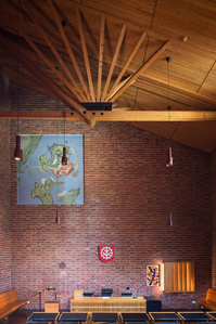 Interior council chamber of Saynatsalo Town Hall designed by Alvar Aalto, showing the red brick wall and wooden roof.