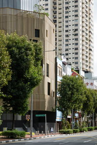 Street view of a golden curtain wall of an office building in Hongkong Street designed by Formwerkz Architects.