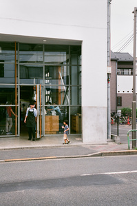 A staff opening the door for a boy at a Blue Bottle Coffee outlet in Japan.